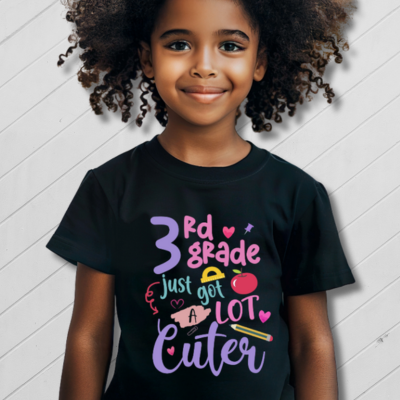 Child wearing a black t-shirt with colorful text on a white background