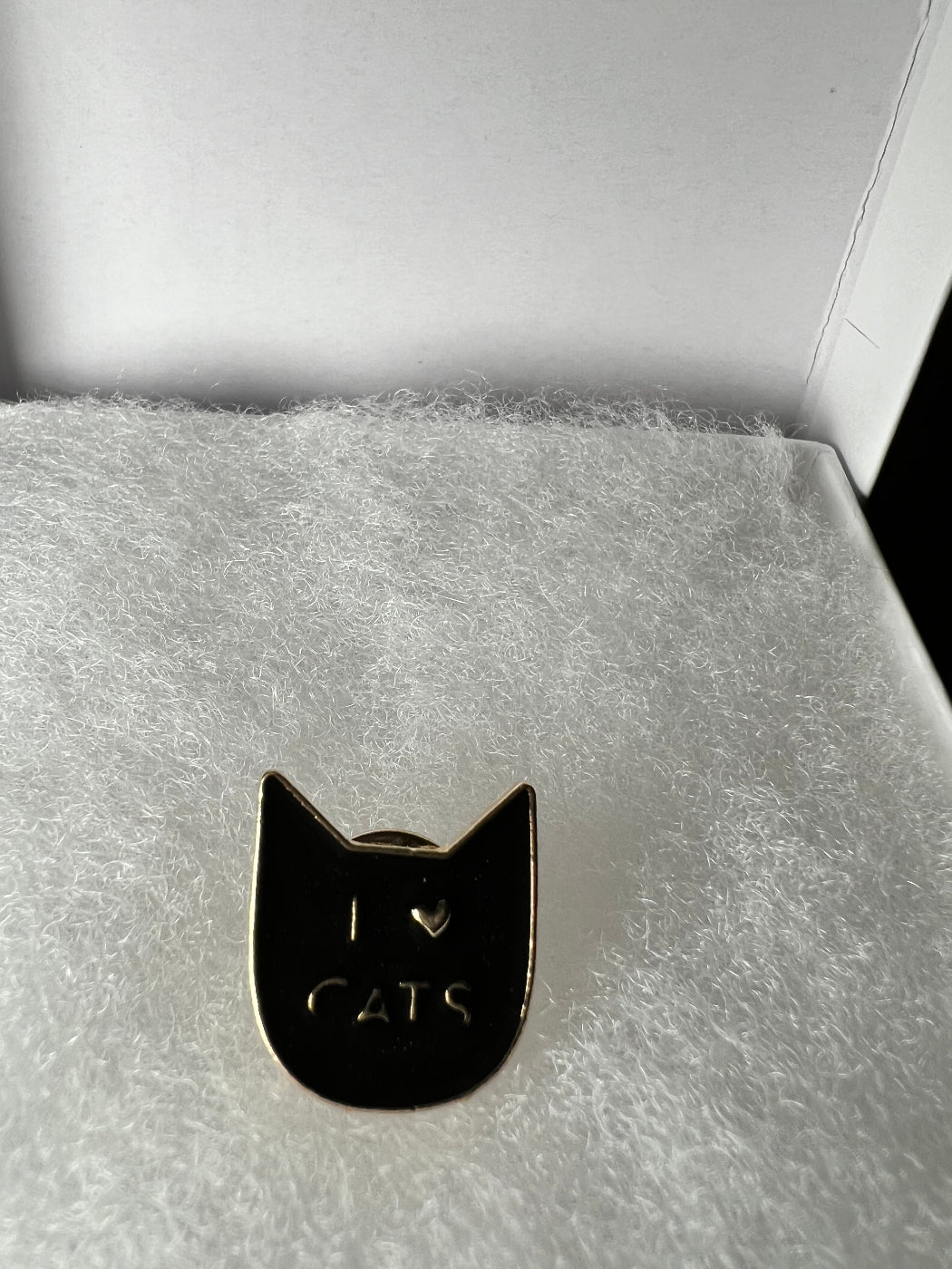 A black cat face with the words: I heart cats in a gift box.