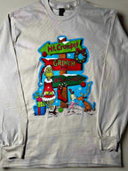 A cream-colored t-shirt with a graphic design featuring the character 'The Grinch' and a whimsical road sign pointing to Mt. Crumpit and Whoville.