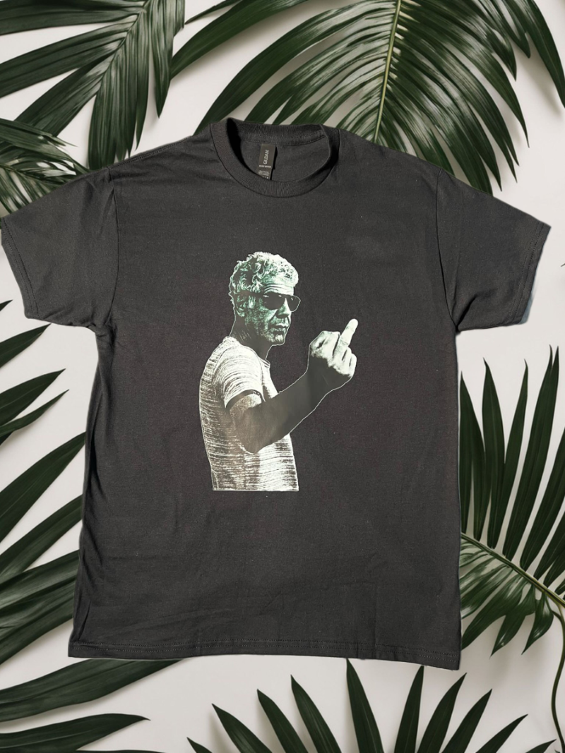 Black t-shirt with graphic design of a person pointing on a background of green leaves.