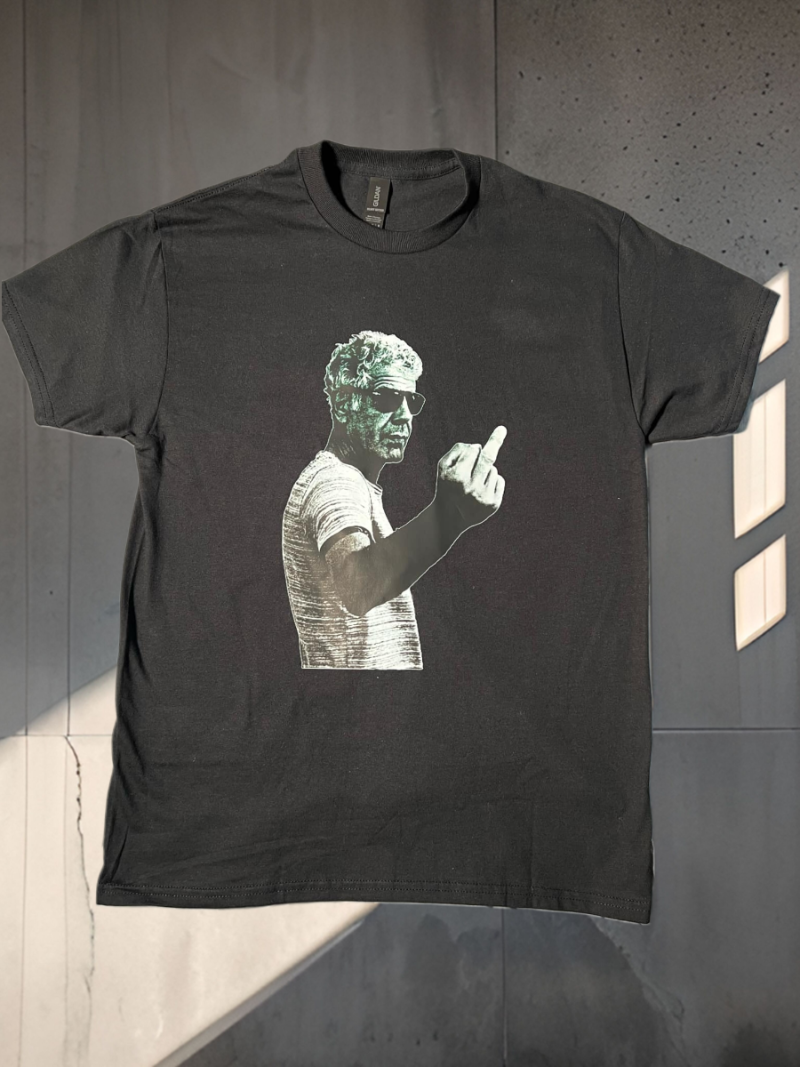 Black t-shirt with graphic design of a person pointing on a plain background