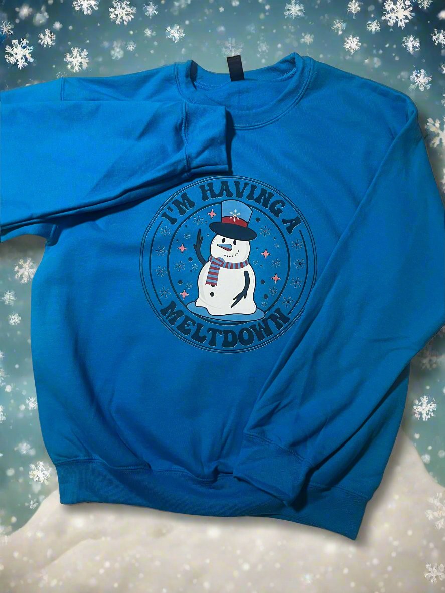 Blue sweatshirt with melting snowman graphic and the phrase “I’m Having a Meltdown”