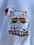 Close up of fun embroidered pride month shirt with cat rainbow sunglasses
