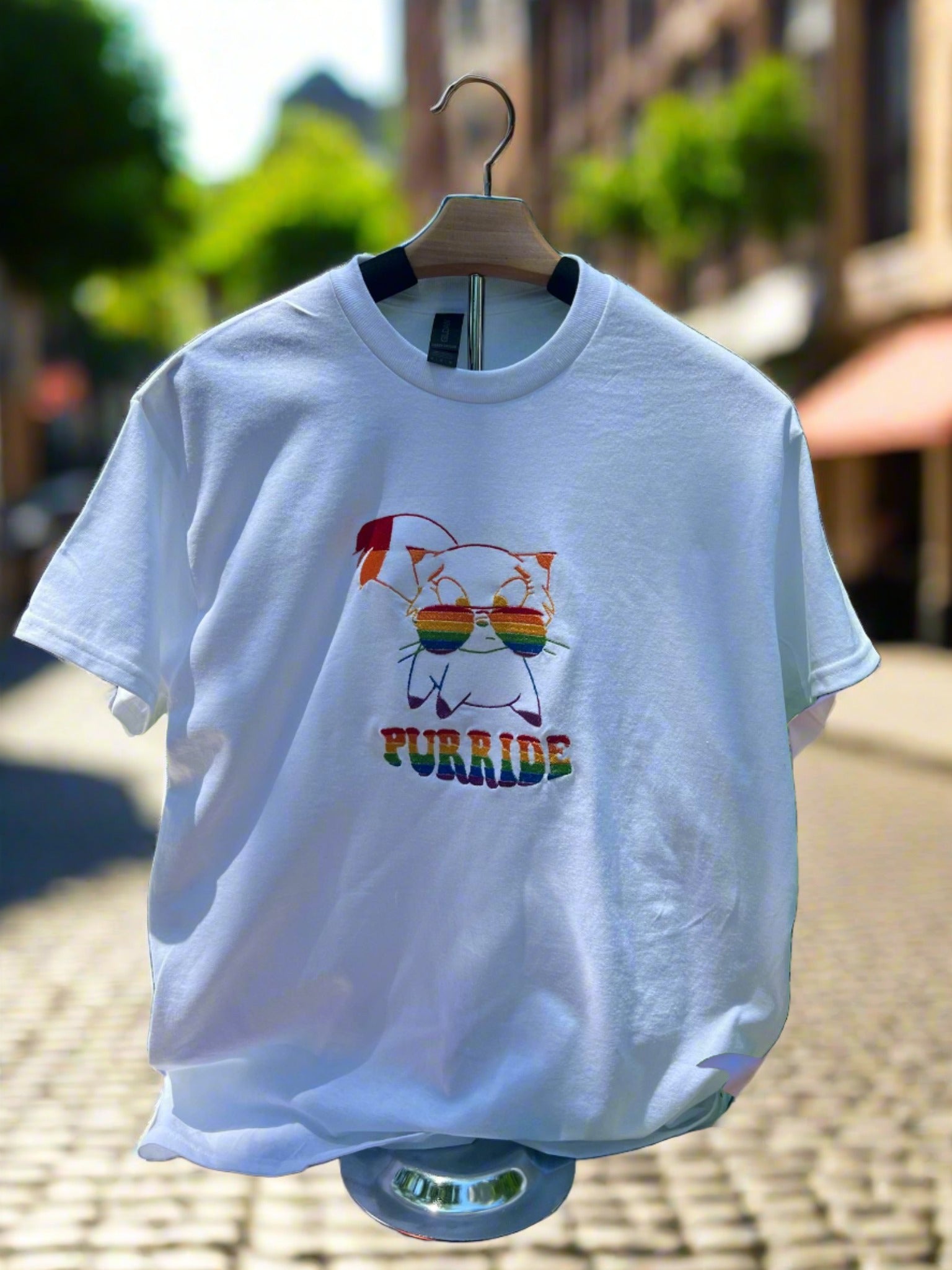 White tee with a colorful cat with rainbow colored glasses and the word Purride on it.