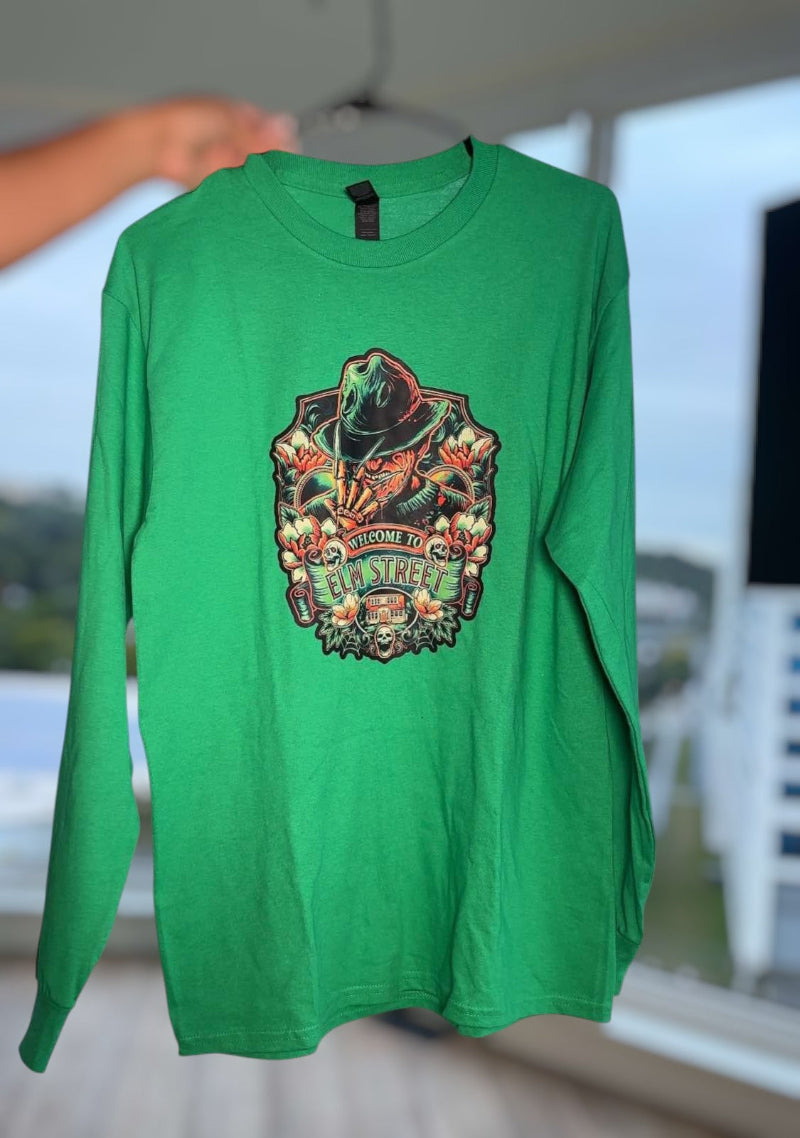 Green long-sleeve shirt with a colorful graphic design on a hanger.