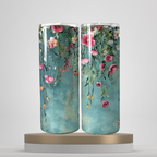 A set of three stainless steel tumblers with a floral design, featuring pink and white flowers and green leaves on a blue background, displayed on a wooden surface.
