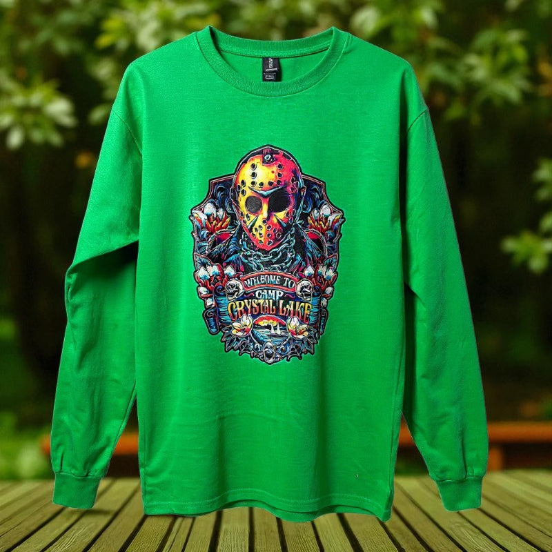 Green long-sleeve shirt with a colorful graphic design on a wooden surface with a blurred natural background
