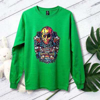Green long-sleeve shirt with a colorful graphic design on a wooden surface with a blurred natural background