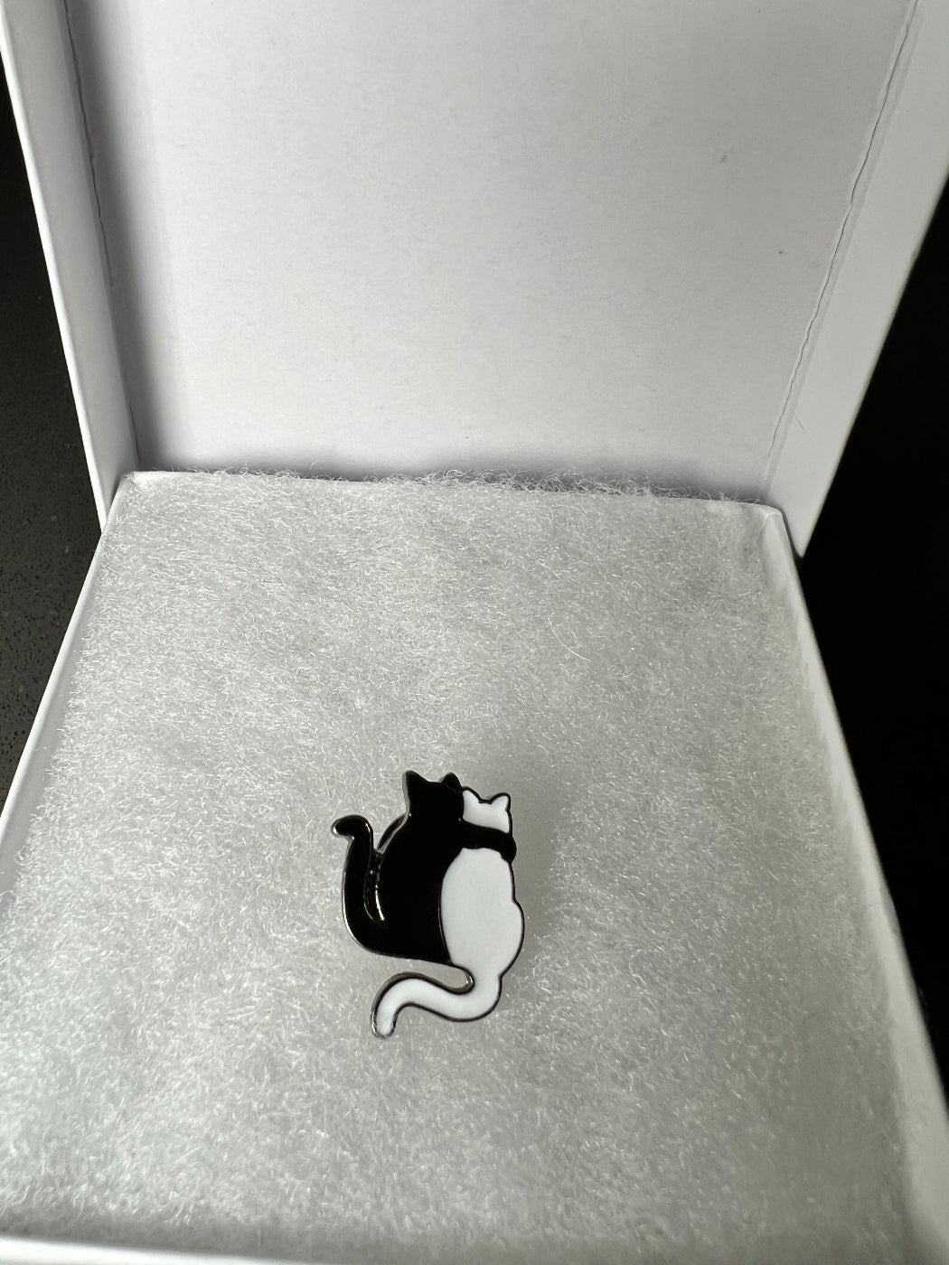 Lapel Pin of a black cat with a white cat in a white gift box.