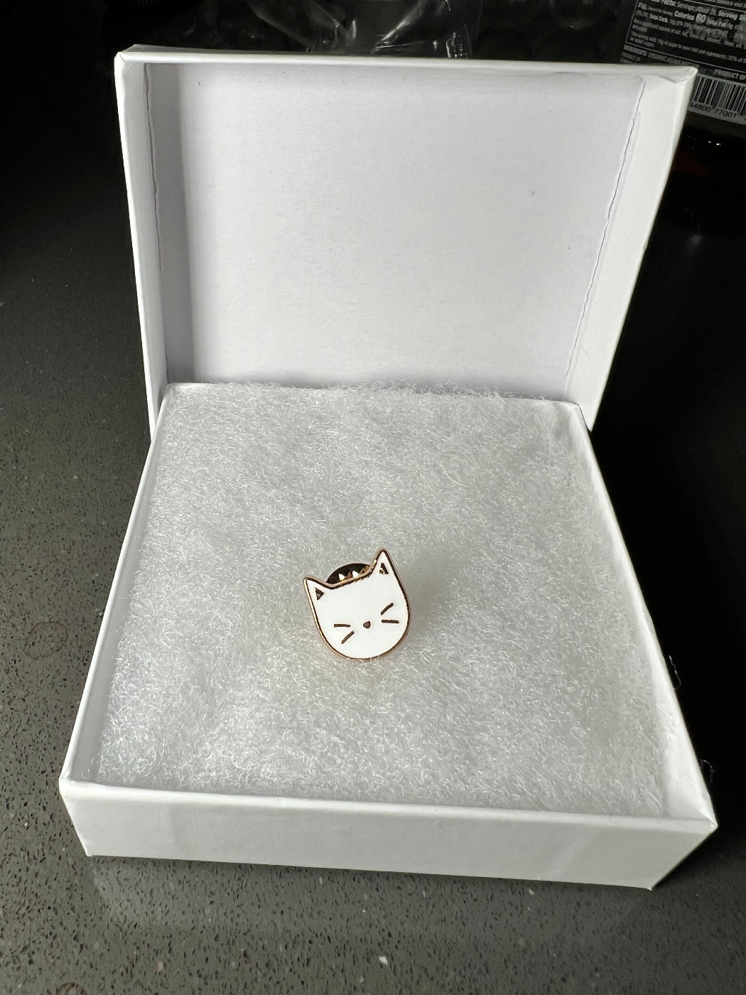 Lapel Pin of a white cat face in a white gift box.