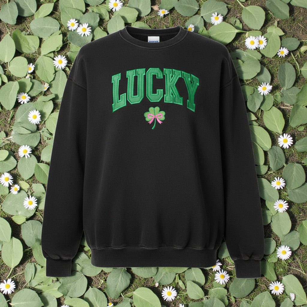 Black sweatshirt with 'LUCKY' and a shamrock design on a green leafy background.