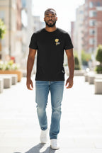 Man wearing a black t-shirt with a logo and light blue jeans walking on a city street.