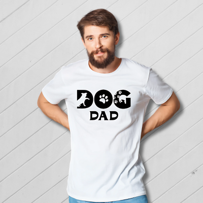 Man wearing a white t-shirt with 'DOG DAD' text and paw prints on a plain background