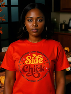 Model wearing orange Side Chick Thanksgiving T-shirt in holiday kitchen with side dishes on the table 