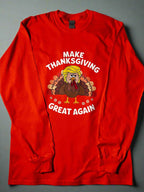 An orange t-shirt with a graphic of a turkey and the text 'Make Thanksgiving Great Again' printed on the front.