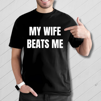 Person wearing a black t-shirt with 'MY WIFE BEATS ME' text, pointing to the shirt.