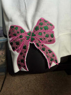 Pink bow with green accents on a white background