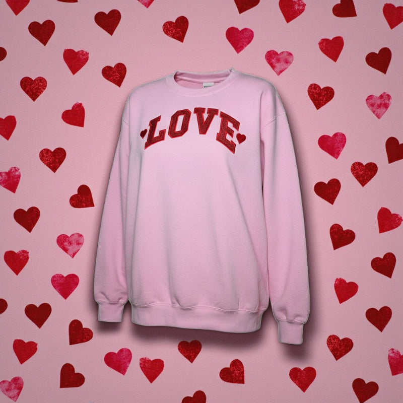 Pink sweatshirt with 'LOVE' text on a pink background with red hearts