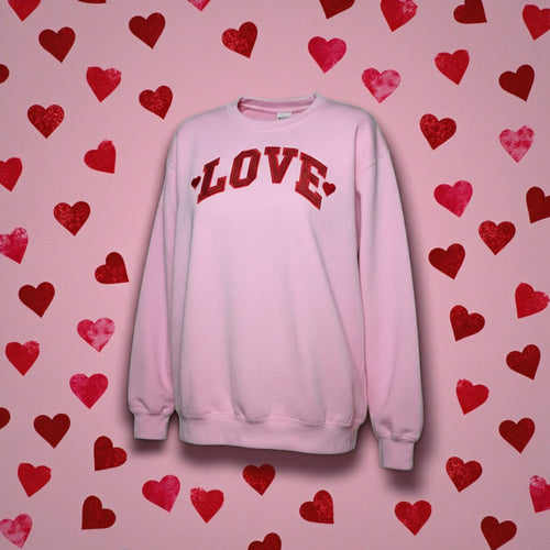 Pink sweatshirt with 'LOVE' text on a pink background with red hearts
