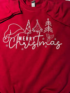 Close up of a red sweatshirt with 'Merry Christmas' text and a graphic of a Santa hat and Christmas trees on it.