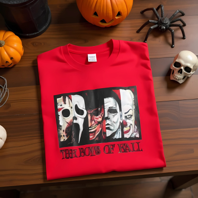 Man wearing a red t-shirt with graphic design in a Halloween-themed room.