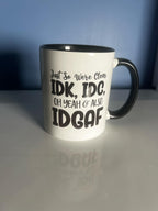 A white ceramic mug with black text that reads 'Just so we’re clear: IDK, IDC... oh yeah, & also IDGAF'.