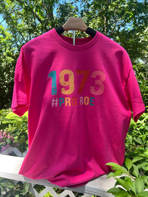Unisex protest shirt supporting equality and human rights on a stand outside.