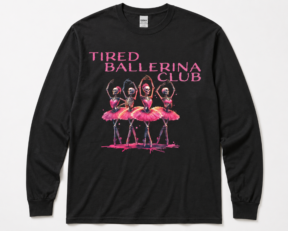 A black long-sleeve t-shirt with a graphic print on the front. The graphic features the text 'TIRED BALLERINA CLUB' in pink, above an illustration of four ballerinas in pink tutus with skeletal faces.