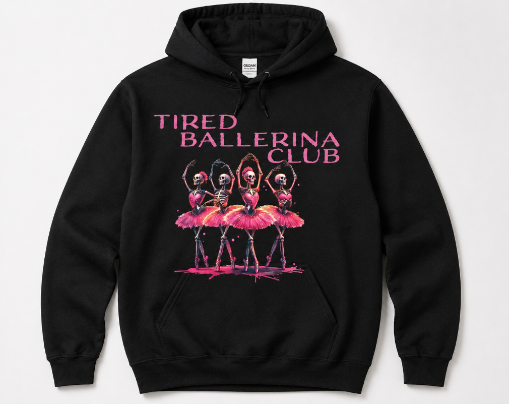 A black pullover hoodie with a graphic print of four ballerinas in pink tutus under the text 'TIRED BALLERINA CLUB' in pink, shown on a light gray background.