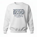 White sweatshirt with 'Blessed to be a blessing' text on a white background