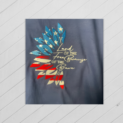 Navy blue shirt with colorful leaf design and text on a light gray background