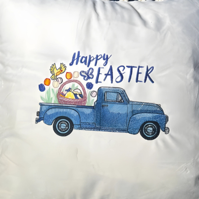 beige embroidered throw pillow with a vintage blue truck filled with spring flowers and the text 'Happy Easter' embroidered on it