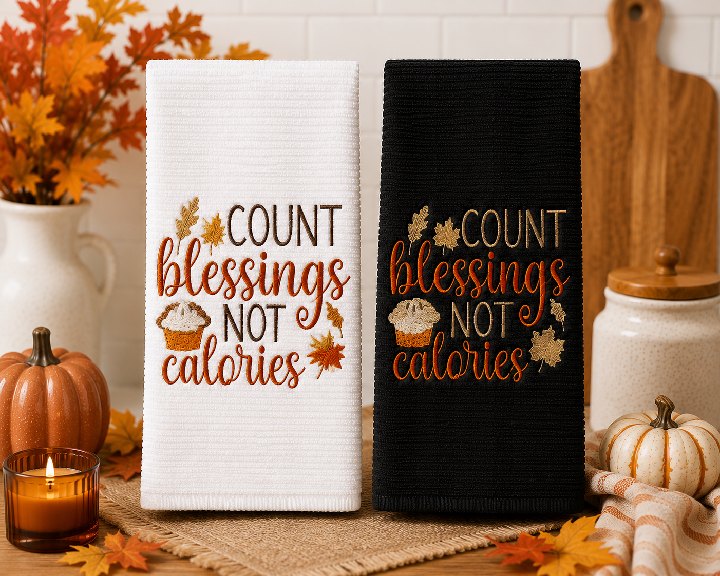 Black and white embroidered kitchen towels featuring the phrase "Count Blessings Not Calories" with autumn leaves and pumpkin pie, displayed together in a cozy farmhouse kitchen decorated for the fall season.