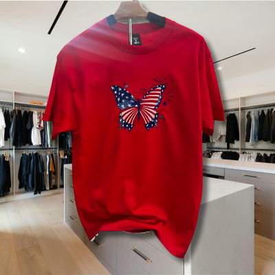 Butterfly shirt with fireworks design in patriotic colors with the ocean as a backdrop.