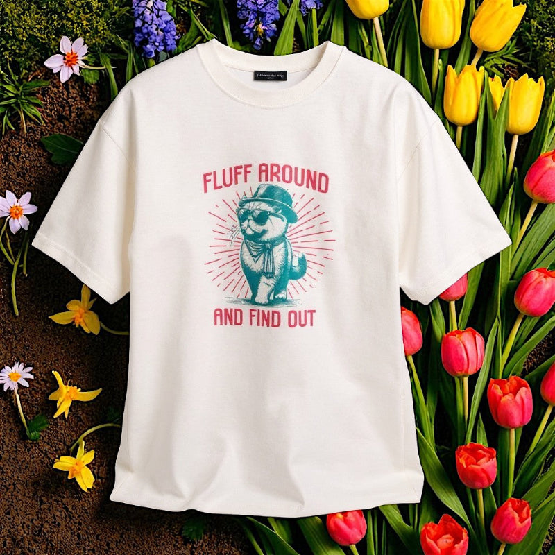 White t-shirt with a graphic design of a bear wearing a hat and scarf, surrounded by flowers.
