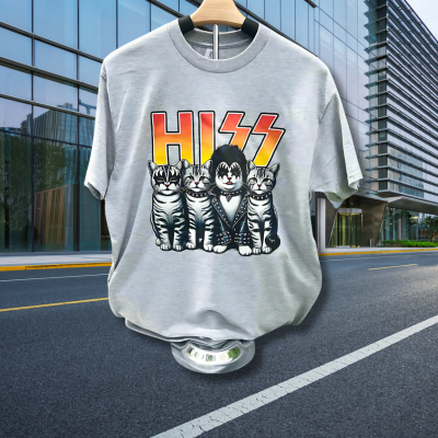 Gray t-shirt with 'KISS' cat graphic design on a hanger against a city street background