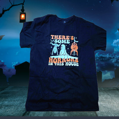 Black tee with the words: There's Some Horrors in This House with a spooky blue background