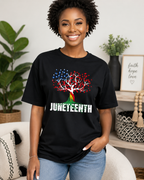 Smiling woman wearing a black Juneteenth graphic T-shirt featuring a colorful freedom tree design and distressed "Juneteenth" lettering in a bright modern home setting.