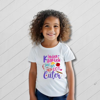 Child wearing a white t-shirt with colorful text on a light wooden background