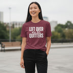 Person wearing a maroon t-shirt with text outdoors