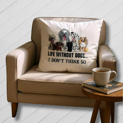 Beige armchair with a pillow featuring dog illustrations and text, next to a wooden table with a cup and book.