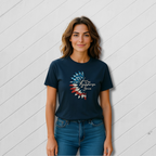 Woman wearing a navy blue t-shirt with a graphic design against a white wooden panel background
