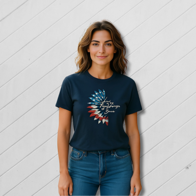 Woman wearing a navy blue t-shirt with a graphic design against a white wooden panel background