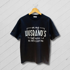 Black t-shirt with white text on a wooden hanger against a light gray background