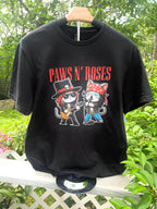 Black Paws N’ Roses graphic t-shirt hanging outdoors on wooden hanger.