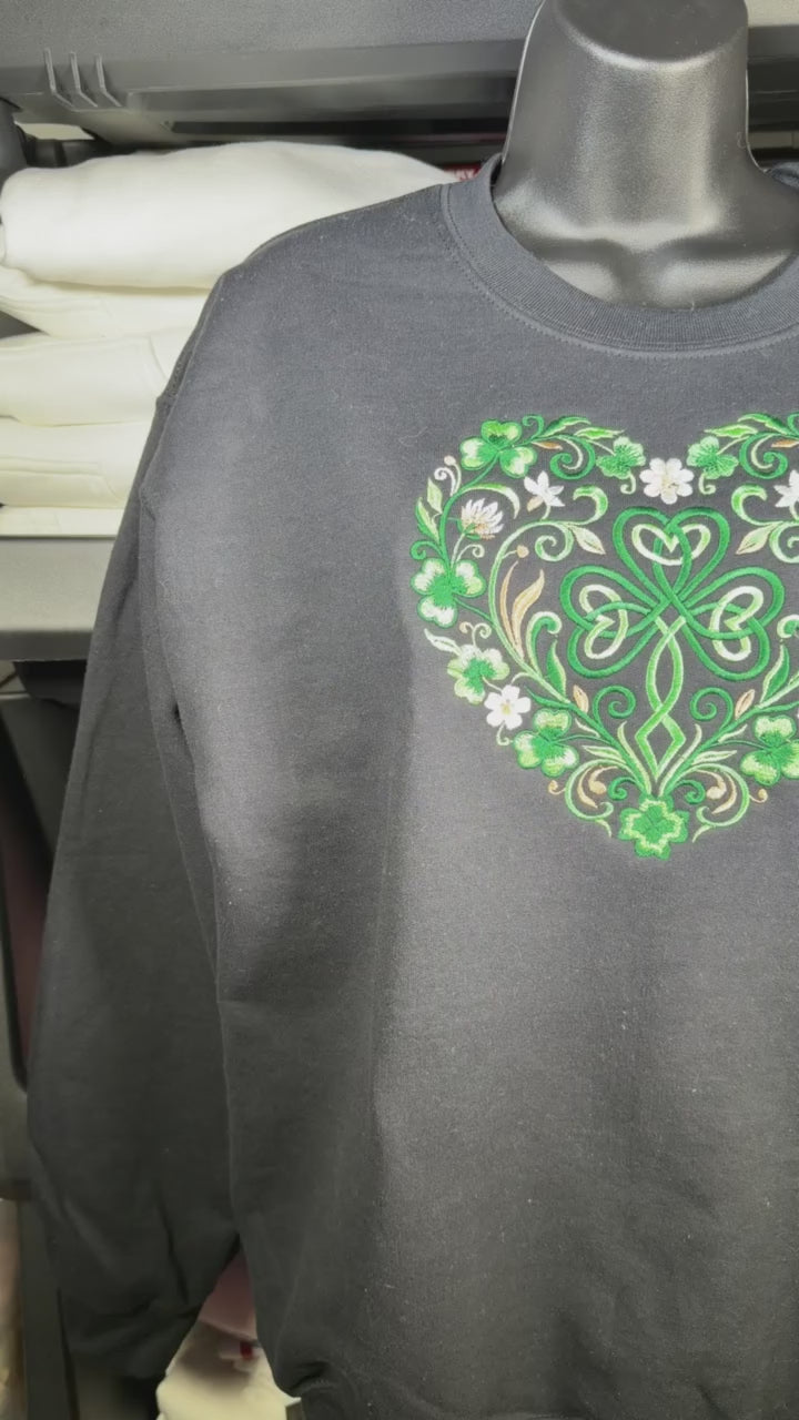 Black crewneck sweatshirt featuring intricate green Celtic clover heart design with floral detailing
