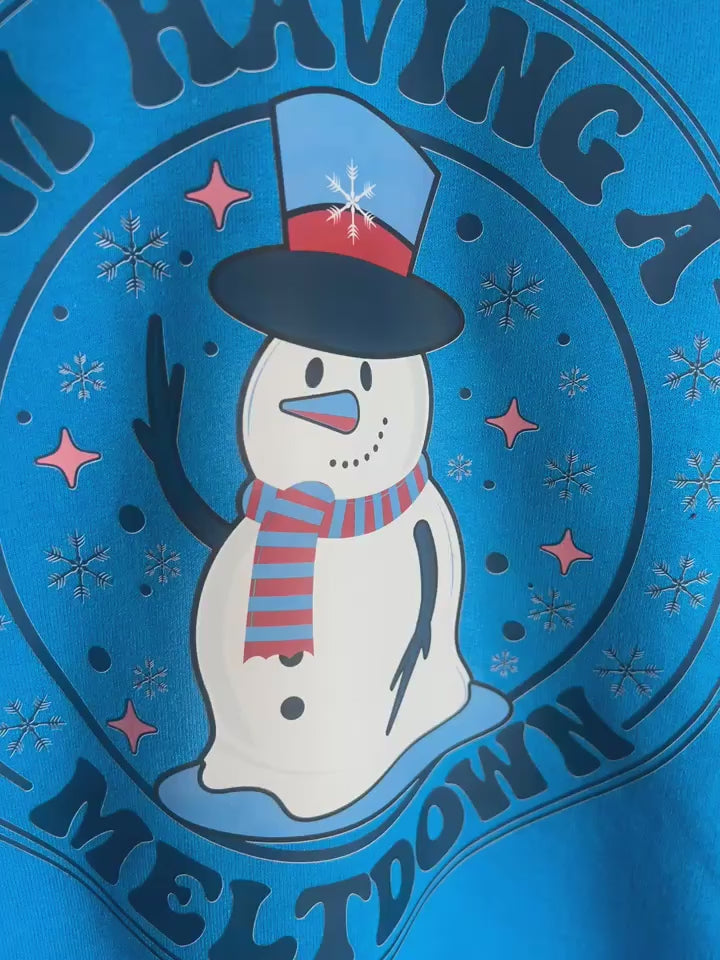 Video of cozy winter graphic sweatshirt with funny melting snowman design