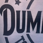 Video close-up detail of bold black graphic text on white cotton shirt.