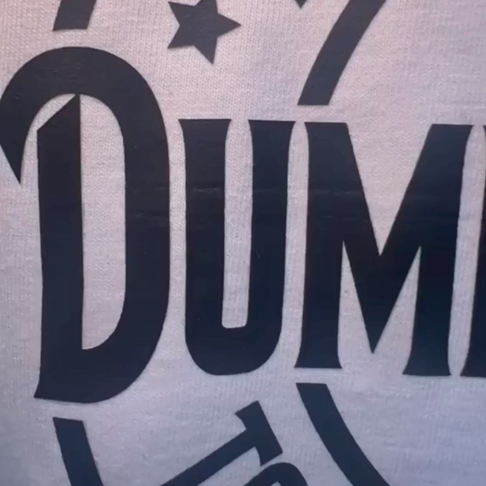 Video close-up detail of bold black graphic text on white cotton shirt.