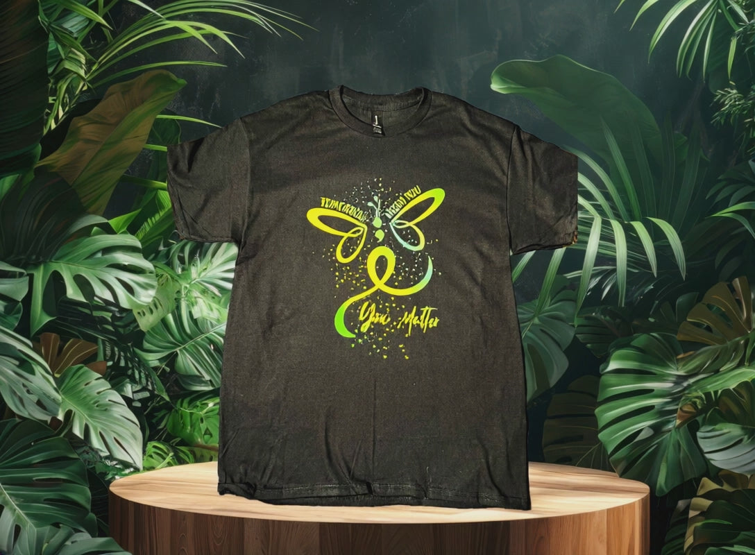 Video of Black t-shirt with a green butterfly with jungle background 